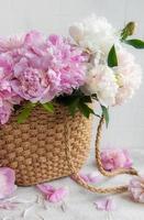 bolsa de vime com flores de peônia foto
