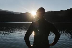 atleta de triatlo iniciando treinamento de natação no lago foto