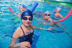 grupo de crianças felizes na piscina foto