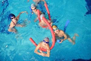 grupo de crianças felizes na piscina foto