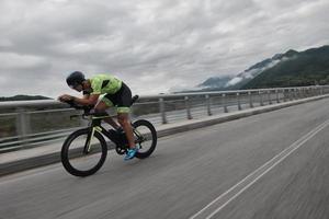 atleta de triatlo andando de bicicleta no treinamento matinal foto