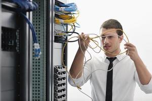 jovem engenheiro de TI na sala do servidor do datacenter foto