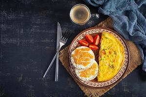 omelete frito com carne e ervas. delicioso café da manhã com ovos, bolinhos de arroz tufado e salmão. vista do topo foto