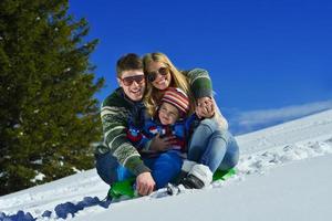 família se divertindo na neve fresca nas férias de inverno foto