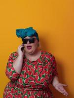 mulher loira plus size conversando falando por smartphone sobre fundo amarelo sorrindo com uma ideia ou pergunta apontando o dedo com cara de feliz, número um foto