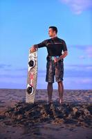 retrato de um jovem kitsurf na praia ao pôr do sol foto