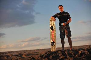 retrato de um jovem kitsurf na praia ao pôr do sol foto