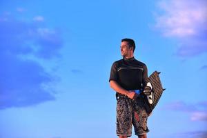 retrato de um jovem kitsurf na praia ao pôr do sol foto