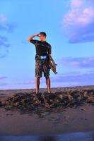 retrato de um jovem kitsurf na praia ao pôr do sol foto