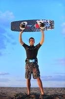 retrato de um jovem kitsurf na praia ao pôr do sol foto