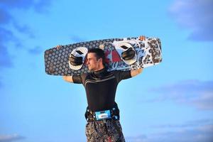 retrato de um jovem kitsurf na praia ao pôr do sol foto