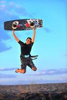 retrato de um jovem kitsurf na praia ao pôr do sol foto