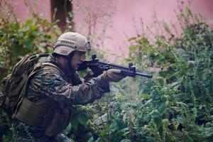 soldado em ação mirando na ótica de mira a laser de arma foto
