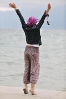 mulher jovem e bonita na praia com cachecol foto