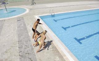 feliz jovem família se divertir na piscina foto