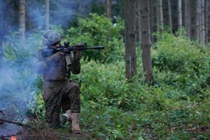 soldado em ação mirando na ótica de mira a laser de arma foto