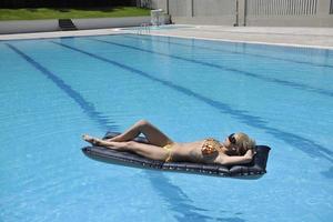 linda mulher relaxar na piscina foto