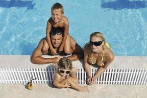 feliz jovem família se divertir na piscina foto