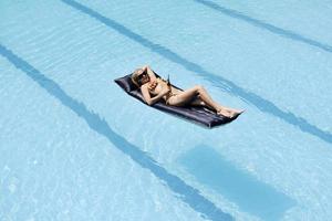 linda mulher relaxar na piscina foto