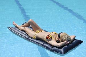 linda mulher relaxar na piscina foto