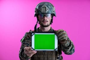 soldado mostrando um tablet com uma tela verde em branco foto