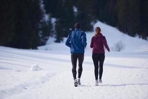 casal correndo lá fora na neve foto