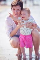 mãe e bebê na praia se divertem foto