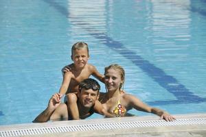 feliz jovem família se divertir na piscina foto