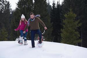 casal se divertindo e andando com sapatos de neve foto