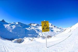 placa de sinal em altas montanhas sob neve no inverno foto