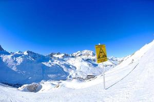 placa de sinal em altas montanhas sob neve no inverno foto