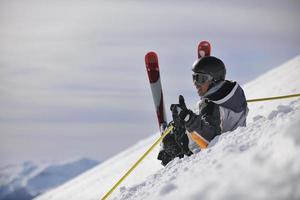 jovem esquiador relaxante no lindo dia ensolarado de inverno foto