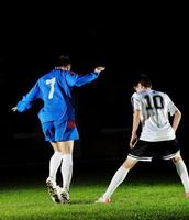 jogadores de futebol em ação para a bola foto