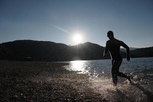 atleta de triatlo iniciando treinamento de natação no lago foto