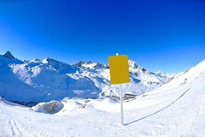 placa de sinal em altas montanhas sob neve no inverno foto