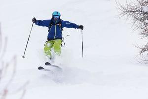 esquiador freeride esquiando na neve em pó profundo foto