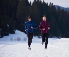 casal correndo lá fora na neve foto