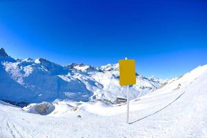 placa de sinal em altas montanhas sob neve no inverno foto