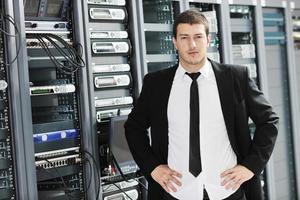 jovem engenheiro de TI na sala do servidor do datacenter foto