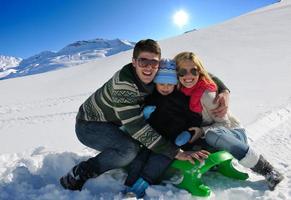 família se divertindo na neve fresca nas férias de inverno foto