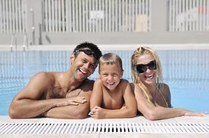 feliz jovem família se divertir na piscina foto