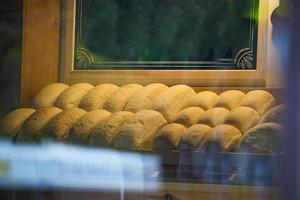 pão assado em uma vitrine de padaria. closeup de pão assado em uma confeitaria típica foto