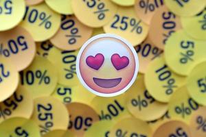 ternopil, ucrânia - 8 de maio de 2022 adesivo emoji de amor em grande quantidade de adesivos amarelos com valores percentuais para sexta-feira negra ou cyber segunda-feira foto