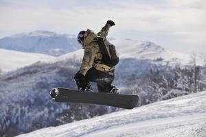 salto e passeio de snowboarder freestyle foto