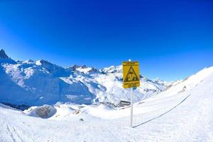 placa de sinal em altas montanhas sob neve no inverno foto