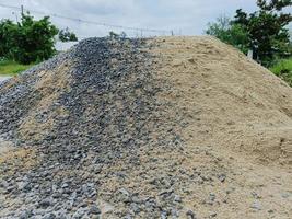 pilha de cascalho ou pedra e areia para construção foto