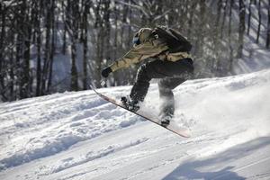 salto e passeio de snowboarder freestyle foto