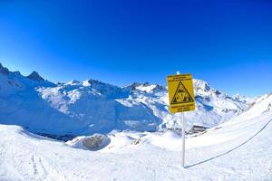 placa de sinal em altas montanhas sob neve no inverno foto