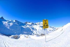 placa de sinal em altas montanhas sob neve no inverno foto