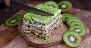 corte um bolo verde com sabor de fruta e kiwi verde fatiado foto